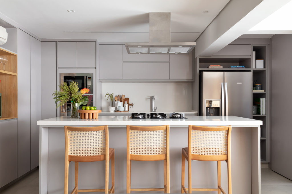 Cozinha gourmet com banquetas de vime e coifa suspensa — projeto de interiores Obrafy no Brooklin